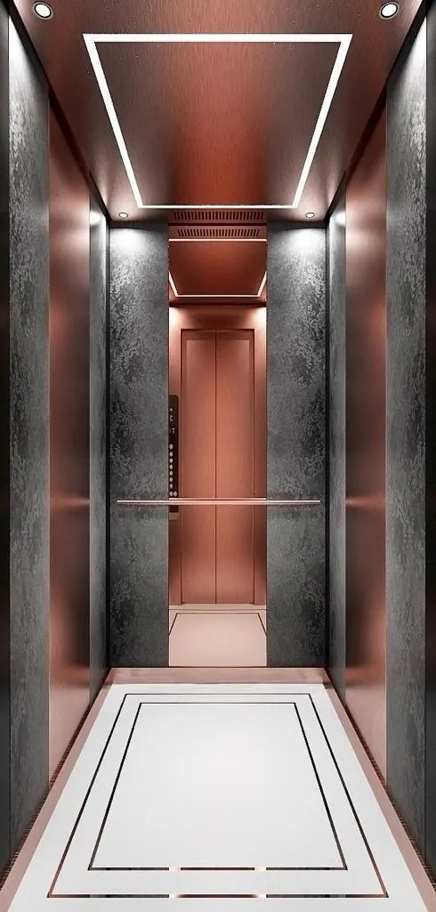 Elevator cabin finished in rose gold and textured steel with a recessed lit ceiling