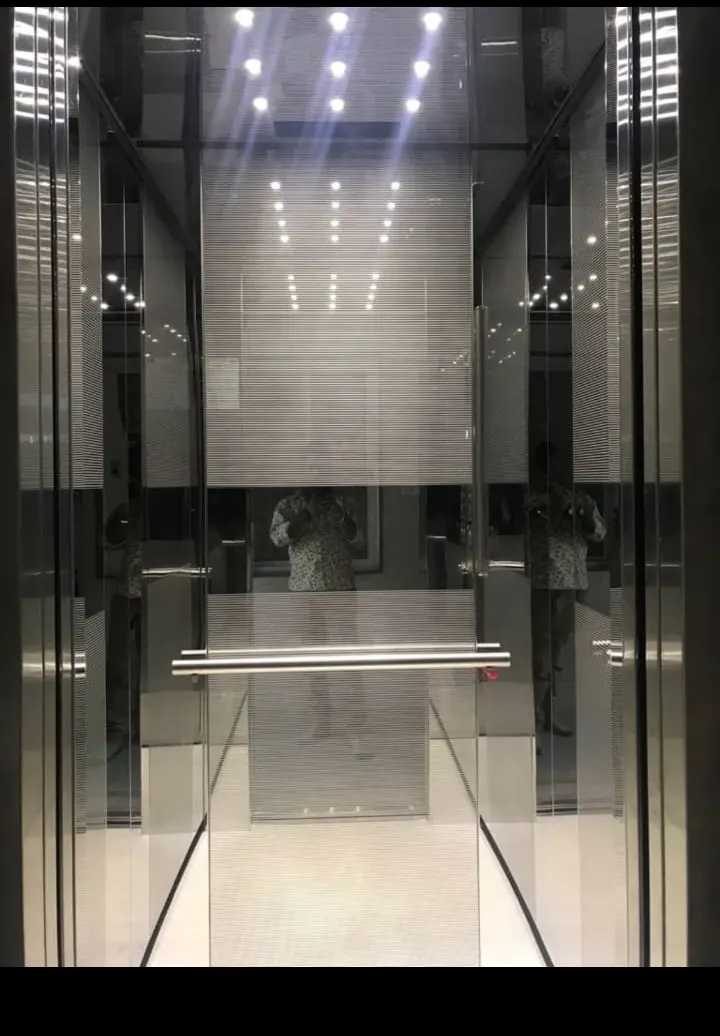 Mirror-finish car running in a glass hoistway at a completed installation